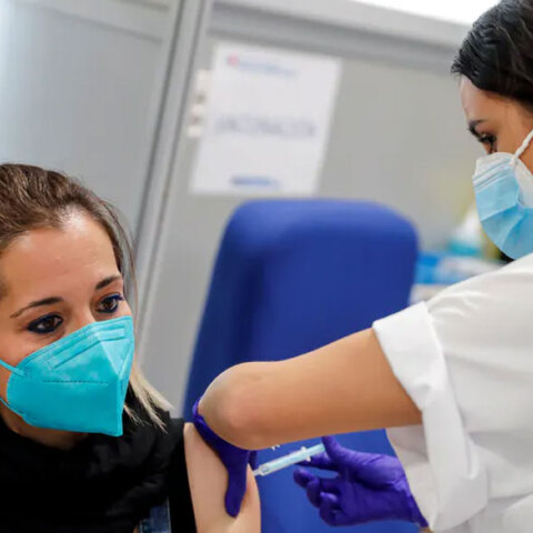 Γυναίκα με μάσκα για τον κορωνοϊό κάνει το εμβόλιο για την Covid-19