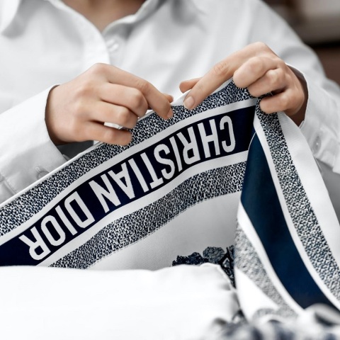 Γυναίκα κρατάει φουλάρι Christian Dior