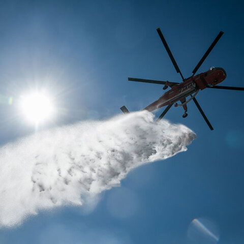 Ελικόπτερο πραγματοποιεί ρίψη νερού στην Κερατέα, όπου η φωτιά βρίσκεται σε ύφεση