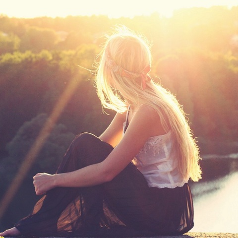 Ένα κορίτσι κάθεται και κοιτά μια λίμνη