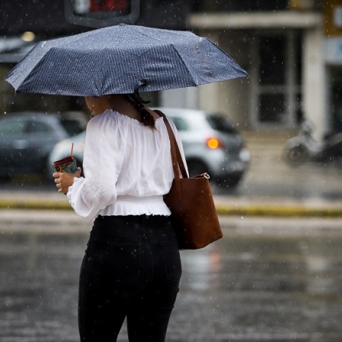 Καταιγίδα - Γυναίκα με ομπρέλα περπατά στη βροχή