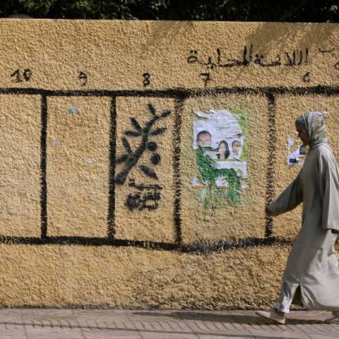 Γυναίκα περπατά στο Ραμπάτ, δίπλα σε έναν τοίχο ζωγραφισμένο με σύμβολα πολιτικών κομμάτων που συμμετέχουν στις βουλευτικές και τοπικές εκλογές στις 8 Σεπτεμβρίου 2021 στο Μαρόκο