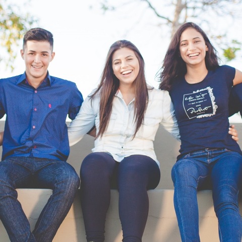 Νέα παιδιά καθισμένα αγκαλιάζονται