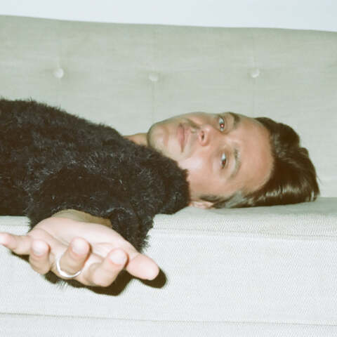 Ο τραγουδιστής George Cosby ξαπλωμένος σε καναπέ απλώνει το χέρι του