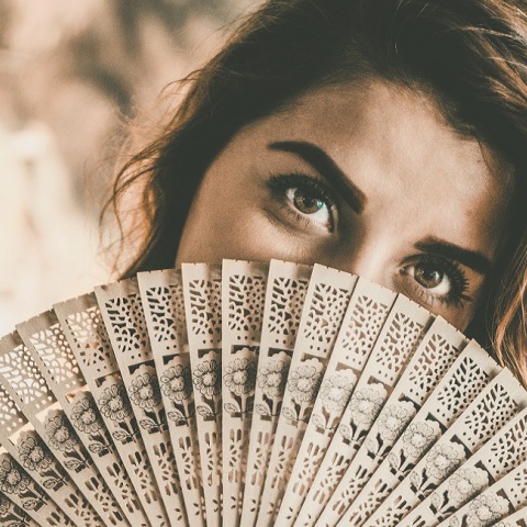 Μια γυναίκα κρατά μια βεντάλια.