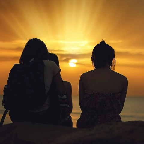 Τρία άτομα βλέπουν το ηλιοβασίλεμα 