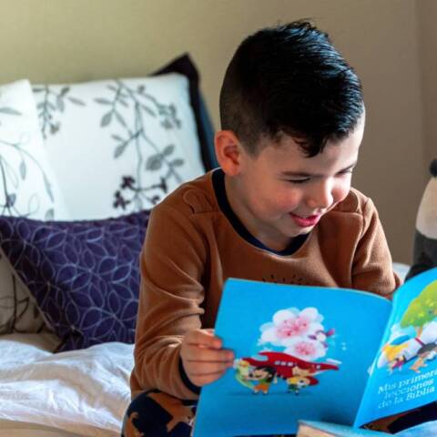 Παιδί στο κρεβάτι που διβάζει βιβλίο