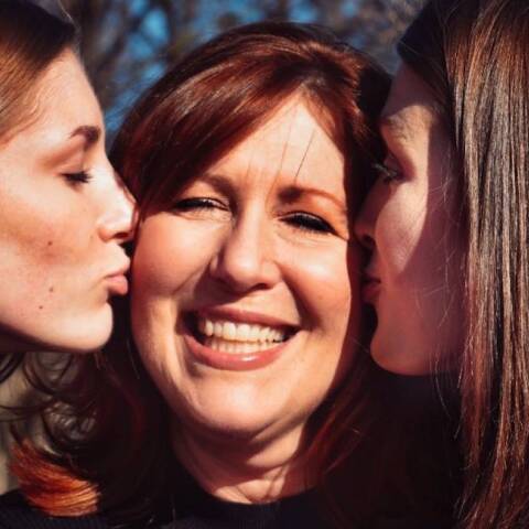 Δύο κόρες φιλάνε τη μητέρα τους στο μάγουλο