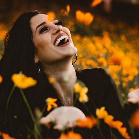 Ενα χαρούμενο κορίτσι ανάμεσα στα λουλούδια.