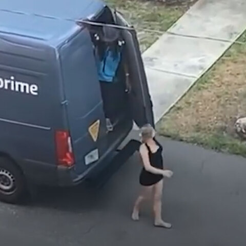Διανομέας της Amazon κρατά ανοιχτή την πίσω πόρτα του βαν για να βγει η γυναίκα με το μίνι φόρεμα