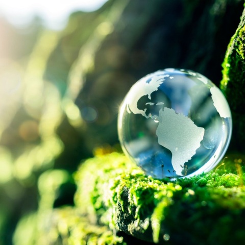 Σταγόνα που μοιάζει με τον πλανήτη γη, ακουμπισμένη σε πόα