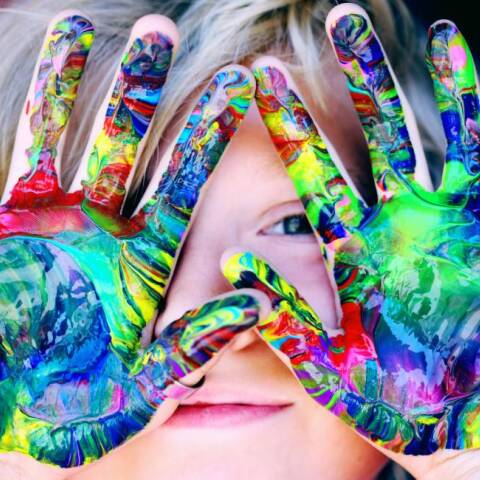 Μικρό παιδί που έχει λερώσει τα χέρια του με χρώμα