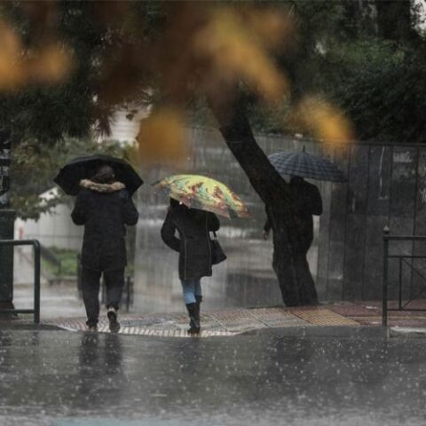Πολίτες με ομπρέλα στη βροχή