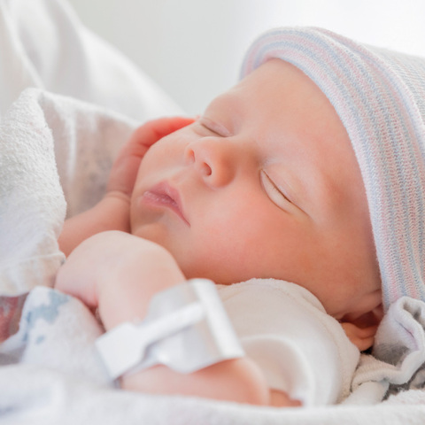 Γιατρός κρατά ένα μωρό στην αγκαλιά του