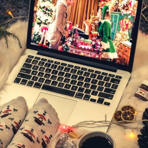 Μια κοπέλα βλέπει χριστουγεννιάτικη ταινία στο λάπτοπ