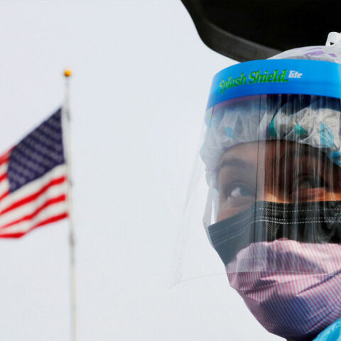 Υγειονομικός στις ΗΠΑ φορά μάσκα για κορωνοϊό με φόντο την αμερικανική σημαία