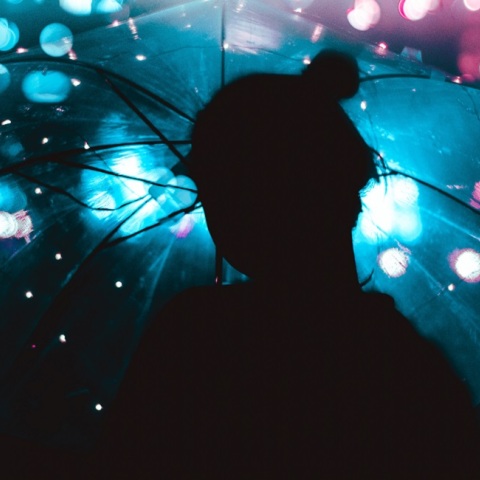 Μια καλλιτεχνική φωτογραφία ενός κοριτσιού που κρατάει μια ομπρέλα. 