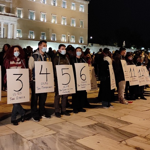 Συγκεντρωμένοι κρατούν πανό έξω από την Βουλή για τις γυναικοκτονίες 