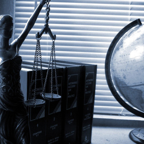 Άγαλμα της θεάς Θέμιδας, θεάς της Δικαιοσύνης, νομοθετικά βιβλία και υδρόγειος σφάιρα πάνω σε γραφείο