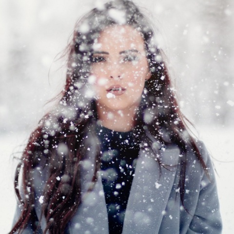 Ένα κορίτσι ποζάρει στα χιόνια.