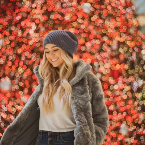 Ξανθιά κοπέλα μπροστά από το χριστουγεννιάτικο δέντρο