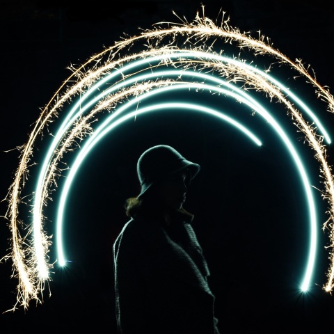 Γυναίκα με καπέλο που φωτίζεται από πυροτεχνήματα
