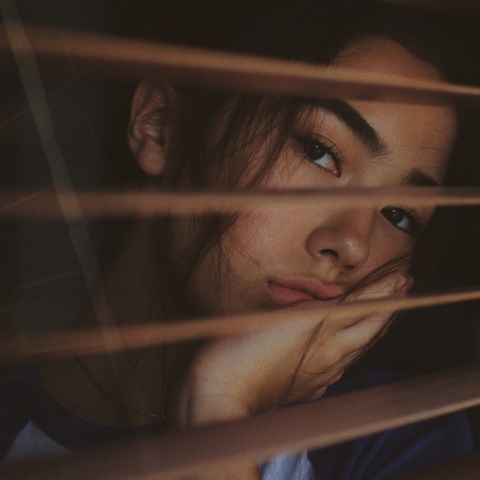 Ένα κορίτσι κοιτάζει έξω από το παράθυρο. 