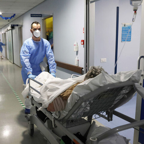 Υγειονομικός οδηγεί ασθενή με κορωνοϊό σε θάλαμο νοσοκομείου στην Κρεμόνα της Ιταλίας