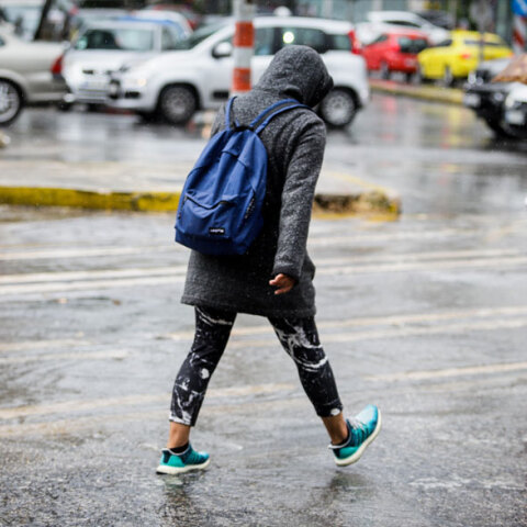 Άνθρωπος περπατά στη βροχή στο κέντρο της Αθήνας