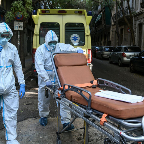 Υγειονομικοί του ΕΚΑΒ για τη μεταφορά ασθενών με κορωνοϊό σπρώχνουν φορείο