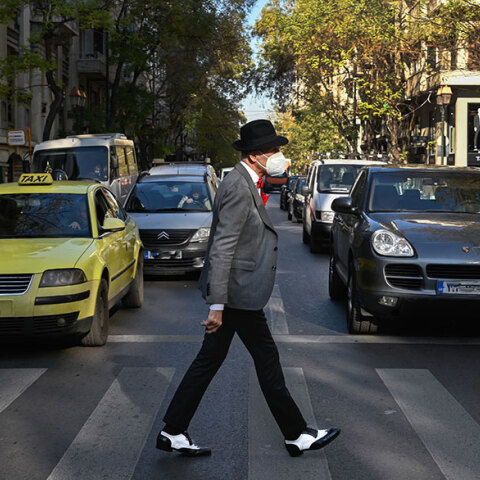 Πολίτης με μάσκα ΚΝ95 διασχίζει διάβαση πεζών στο κέντρο της Αθήνας