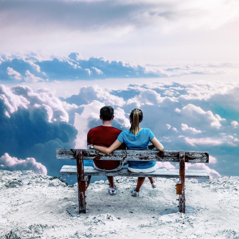 Άνθρωποι που κάθονται σε παγκάκι και βλέπουν τα σύννεφα