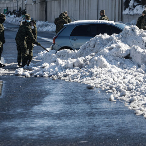 Στην Αττική Οδό στρατιώτες απομακρύνουν χιόνια από αυτοκίνητο