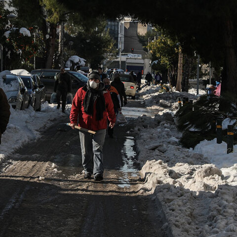 Άνδρας με μάσκα για κορωνοϊό σε δρόμο με χιόνια