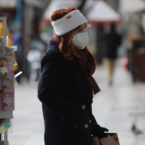 Κρύο - Πτώση θερμοκρασίας - Γυναίκα με σκούφο περπατά στο δρόμο