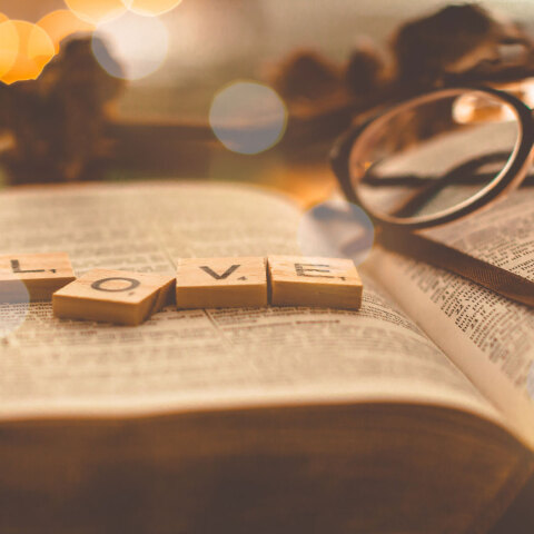 Ανοιχτό βιβλίο με ξύλινα γράμματα ακουμπισμένα που σχηματίζουν τη λέξη LOVE.