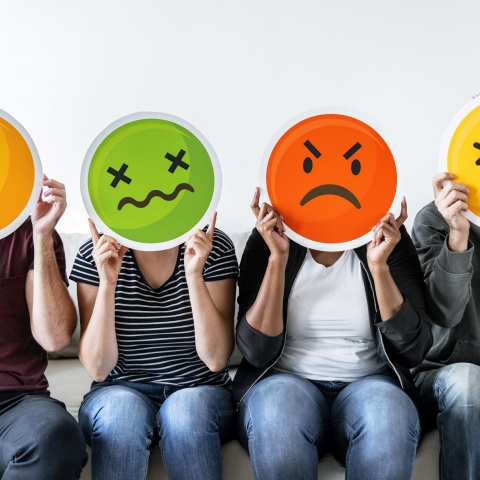 Φωτογραφία που απεικονίζει τέσσερις ανθρώπους να κρύβουν τα πρόσωπά τους με emoticons