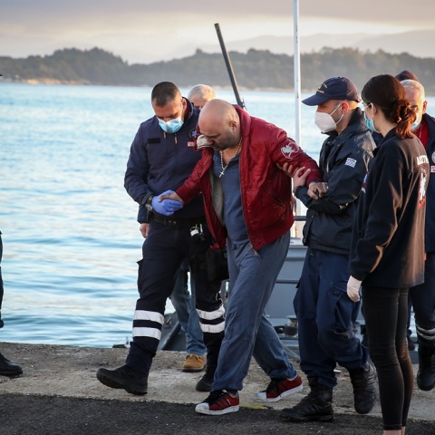 Επιβάτης του πλοίου Euroferry Olympia φτάνει στο λιμάνι της Κέρκυρας όπου θα το παρασχεθούν οι πρώτες βοήθειες - Υποβασταζόμενος από στελέχη του Λιμενικού