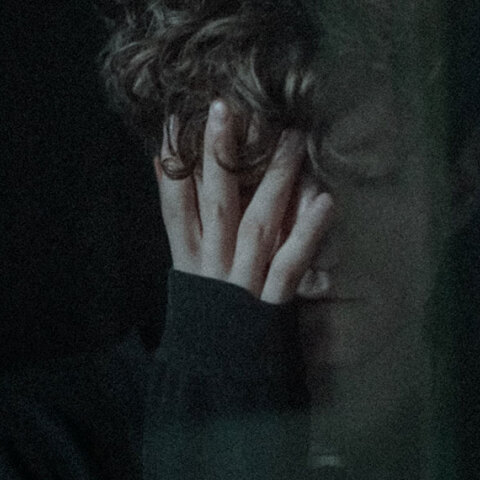 Νέος άντρας που κρύβει το πρόσωπό του