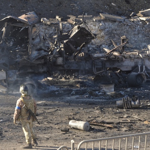 Ουκρανός στρατιώτης στέκεται δίπλα σε βομβαρδισμένο όχημα στην Ουκρανία