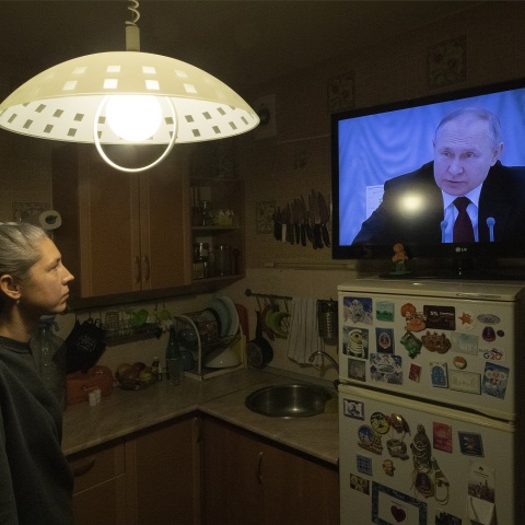 Γυναίκα παρακολουθεί στην τηλεόραση το διάγγελμα του Πούτιν για την εισβολή της Ρωσίας στην Ουκρανία