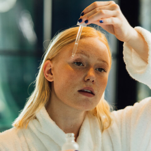 Κοπέλα που βάζει σέρουμ στο πρόσωπό της