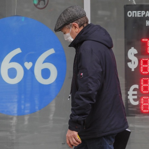 Ρωσία: Άνδρας μπροστά από πίνακα ισοτιμίας για το ρούβλι με το ευρώ