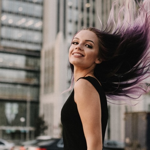 Ένα κορίτσι στο δρόμο χαμογελάει. 