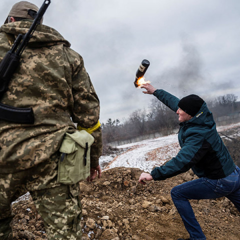 Πολίτης εκτοξεύσει μια βόμβα μολότοφ ενώ στο πλάι του στέκεται ένας Ουκρανός στρατιώτης. REUTERS/Viacheslav Ratynskyi