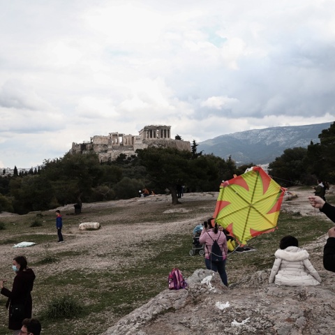 Πολίτες με μάσκα πετούν χαρταετό με φόντο την Ακρόπολη