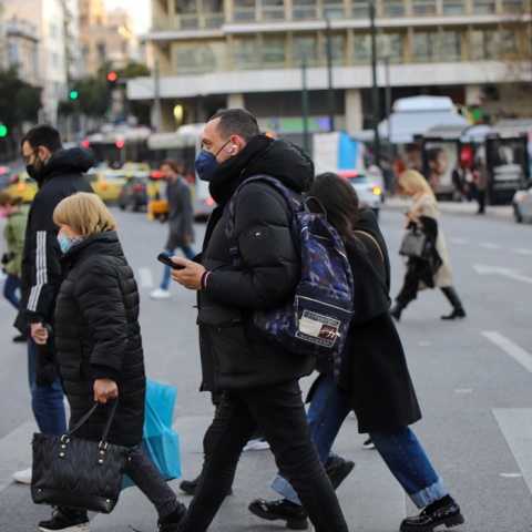 Πολίτες που φορούν μάσκα περπατούν στο κέντρο της Αθήνας