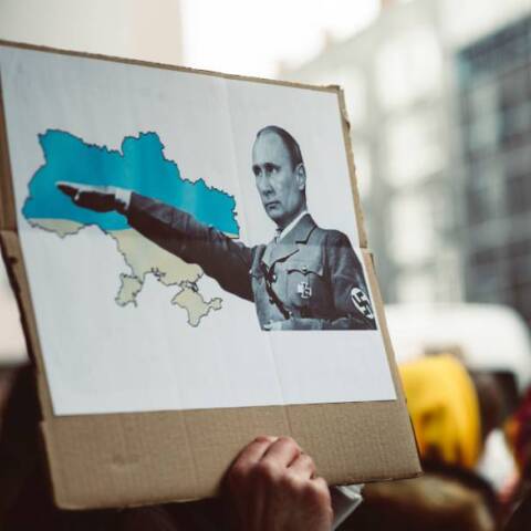 Πλακάτ που προσομοιάζει τον Βλαντιμίρ Πούτιν με τον Αδόλφο Χίτλερ μετά την εισβολή της Ρωσίας στην Ουκρανία