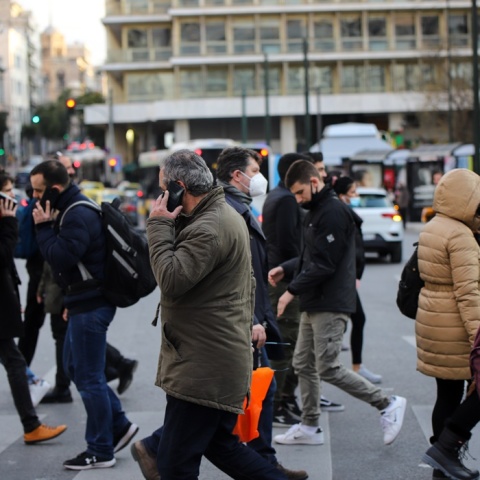 Πολίτες με μάσκα προστασίας από τον κορωνοϊό περπατούν στο κέντρο της Αθήνας