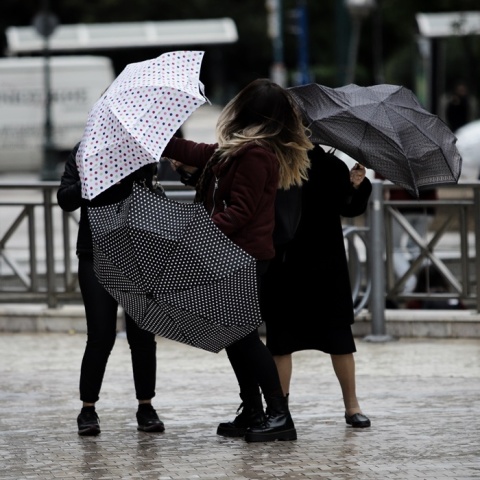 Βροχή στην Αθήνα: Πολίτες ανοίγουν την ομπρέλα τους βγαίνοντας από το μετρό